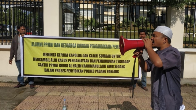 Sejumlah alumni Pesantren Nurul Ikhlas unjuk rasa di depan Mapolda Sumbar, Rabu (20/03). (Irwanda/Langkan.id)