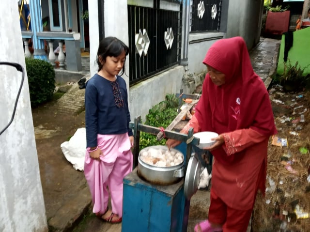 Potret Saminem sedang melayani pelanggan cilik. Foto: Sukabumi Update