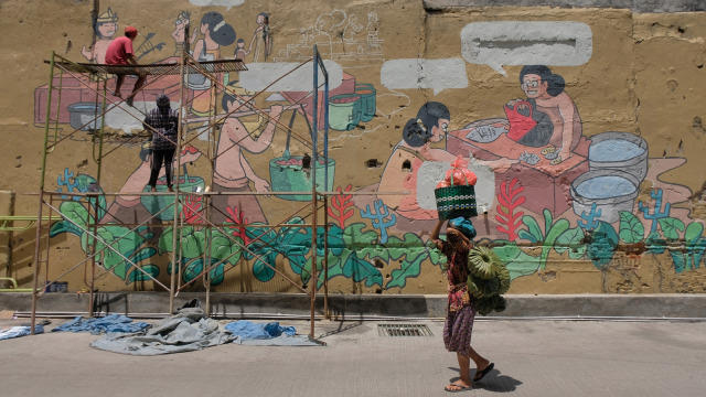 Mahasiswa melukis mural pada tembok Pasar Badung menjelang diresmikan di Denpasar, Bali, Kamis (21/3). Foto: ANTARA FOTO/Nyoman Hendra Wibowo