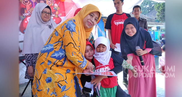 Yani Zatnika Marwan Hamami menyerahkan KIA ke tiga anak di peringatan HAN Tingkat Kecamatan Cicurug. | Sumber Foto:doc sukabumiupdate.