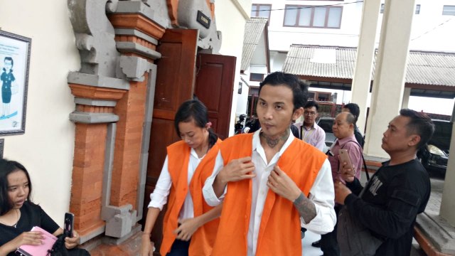 Dua tersangka pemilik 1.181 butir ekstasi berjalan memasuki ruang sidang beragendakan pembacaan tuntutan Jaksa Penuntut Umum di PN Denpasar. Foto: Denita BR Matondang/kumparan