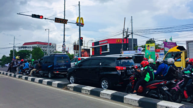 Sejumlah pengendara melintas di lokasi video pengemis yang diduga memiliki mobil, di Jalan Raya Semplak, Bogor. Foto: Muhammad Darisman/kumparan