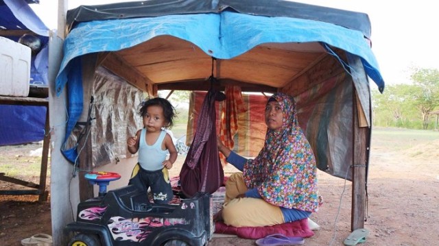 Ibu Asnida sedang mengayun anaknya di tenda pengungsian lokasi Lapangan Golf Palu Jalan Martadinata, Kelurahan Talise Kecamatan Mantikulore Kota Palu, Kamis (21/3). Foto: PaluPoso/Andi Lena