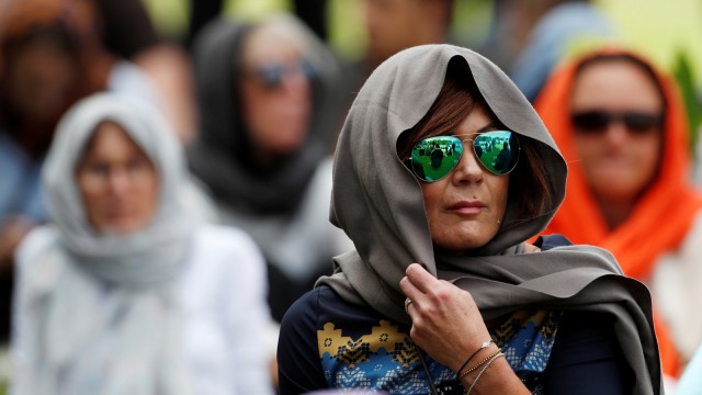 Seorang warga Christchurch mengenakan kerudung sebagai penghormatan korban penembakan Christchurch di Hagley Park di luar masjid Al-Noor, Selandia Baru, Jumat, (22/3). Foto: REUTERS / Jorge Silva