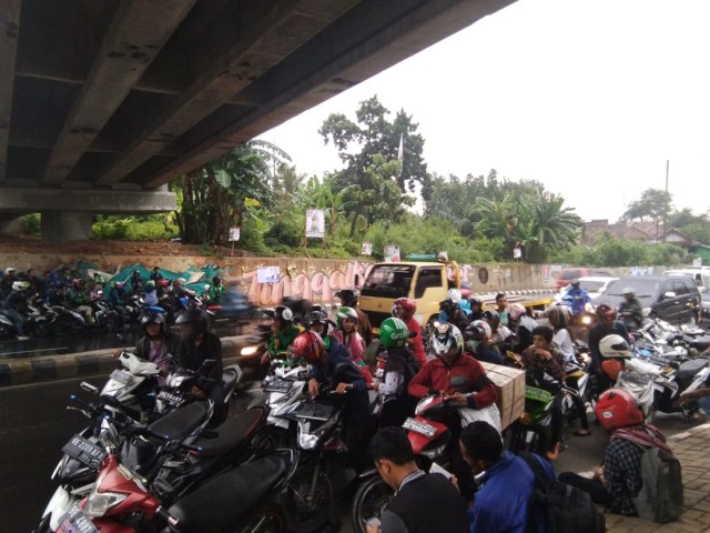 Para pemotor yang meneduh di flyover Pramuka lantaran hujan deras, Jumat (22/3) | Foto : Obbie Fernando/Lampung Geh