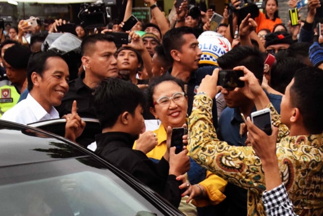 Presiden Jokowi di tengah kerumunan massa bersama Ketua Semeton Jokowi I Gusti Agung Putri Astrid, Jum;at (22/3) - kanalbali/KR3