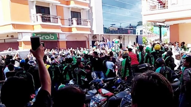 Ratusan driver Grabbike dan Grabcar saat menggelar aksi demo di depan kantor perwakilan Grab yang ada di kawasan Megasmart Manado, Jumat (22/3). Aksi ini menuntut penyesuaian insentif dengan target poin