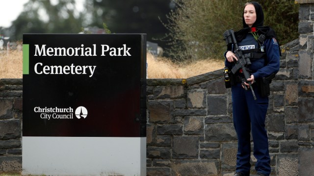Seorang polisi wanita Selandia Baru menggunakan kerudung saat berjaga sebagai penghormatan korban penembakan Christchurch di Memorial Park Cemetery, Selandia Baru, Kamis (21/3). Foto: REUTERS/Jorge Silva