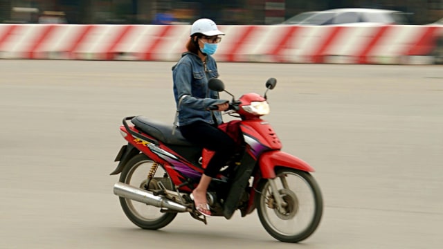 Seorang pengendara motor melintas di jalan raya, Hanoi, Vietnam. Foto: Nugroho Sejati/kumparan
