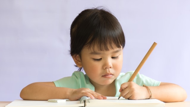 Ilustrasi anak kidal sedang menulis. Foto: Shutterstock