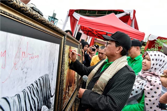Gubernur Jambi Fachrori Umar membubuhkan nama di poster harimau Sumatra. Foto: Humas Pemprov Jambi