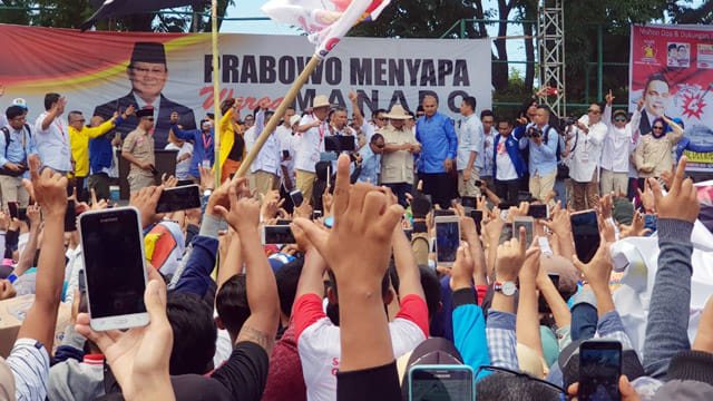 Para pendukung mengangkat salam 2 jari tanda dukungan kepada Calon Presiden Prabowo Subianto saat kampanye perdana di Kota Manado, Minggu (24/3). Massa tetap setia menunggu kehadiran Prabowo di Lapangan Ternate Baru, Kelurahan Ketang Baru Kecamatan Singkil.