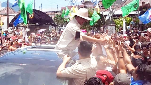 Calon Presiden nomor urut 02, Prabowo Subianto, menyalami warga dari atas mobil saat kampanye di Kota Manado, Sulawesi Utara, Minggu (24/3)