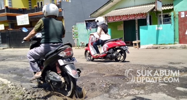 Pengendara sepeda motor melaju pelan menghinrdai lubang di jalan Merdeka, Kelurahan Cikundul, Kecamatan Lembursitu, Kota Sukabumi. | Sumber Foto:Muhammad Gumilang