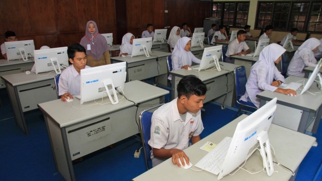 Sejumlah siswa mengikuti Ujian Nasional Berbasis Komputer (UNBK) di Sekolah Menengah Kejuruan (SMK) Negeri 1 Meulaboh, Aceh Barat, Aceh, Senin (25/3). Foto: ANTARA FOTO/Syifa Yulinnas