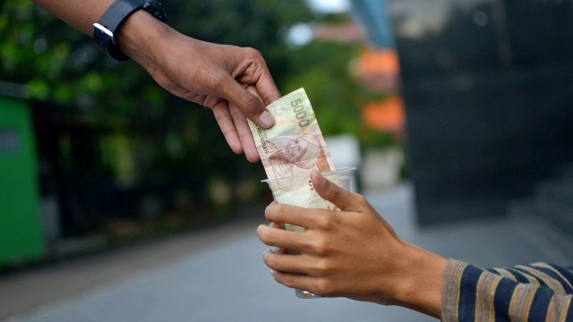 Ilustrasi memberi uang ke pengemis. Foto: Iqbal Firdaus/kumparan