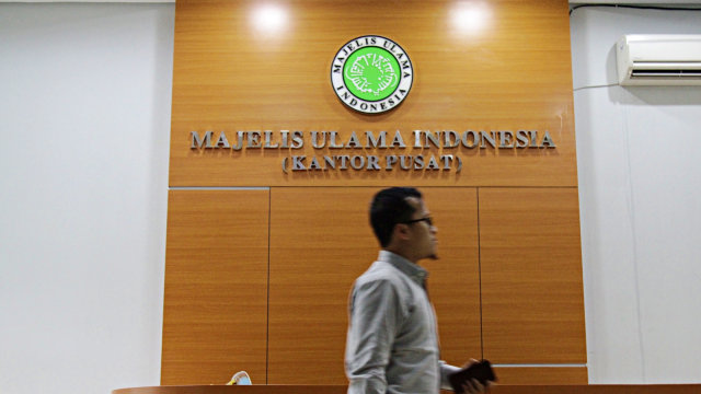 Seorang pegawai berjalan melewati meja resepsionis kantor pusat Majelis Ulama Indonesia (MUI). Foto: Helmi Afandi/kumparan