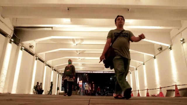 Warga berjalan melewati terowongan jalur pedestrian yang dihiasi lampu warna-warni di Jalan Kendal, dekat Stasiun Sudirman, kawasan Dukuh Atas, Jakarta Pusat, Rabu, (27/3). Foto: Iqbal Firdaus/kumparan