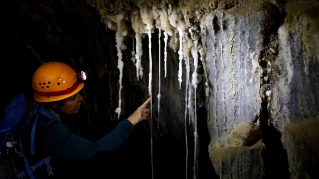 Seorang wanita melihat stalaktit garam di dalam gua Malham gunung Sodom, Israel, Rabu, (27/3). Foto: REUTERS/Nir Elias
