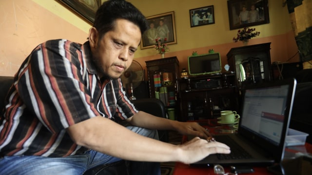Hamdanil, Caleg tunanetra pertama di Aceh dengan laptopnya. Dia tidak bisa melihat, tapi mendengar. Foto: Suparta/acehkini 