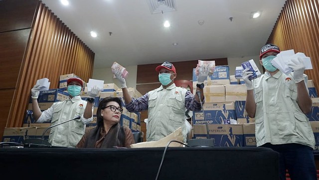 Petugas memegang sejumlah barang bukti berupa uang tunai pada konferensi pers terkait dugaan suap pengiriman pupuk via kapal di Gedung KPK, Jakarta, Kamis, (28/3). Foto: Jamal Ramadhan/kumparan