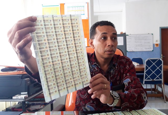 Kepala Kantor PT Pos Indonesia Cabang Jayapura, Alex Nitalessy saat memperlihatkan meterai asli. (Foto Imelda)