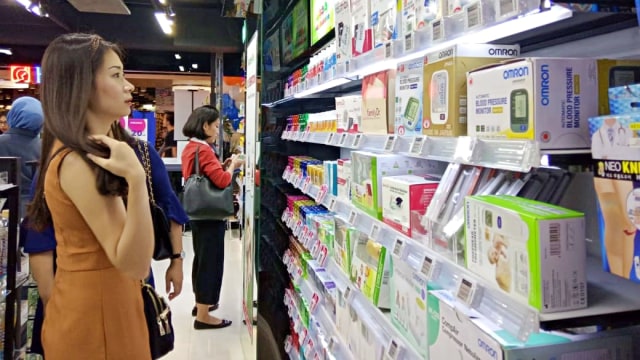 Pengunjung melihat aneka produk farmasi di salah satu gerai apotek di Surabaya, Jawa Timur. Foto: Yuana Fatwalloh/kumparan