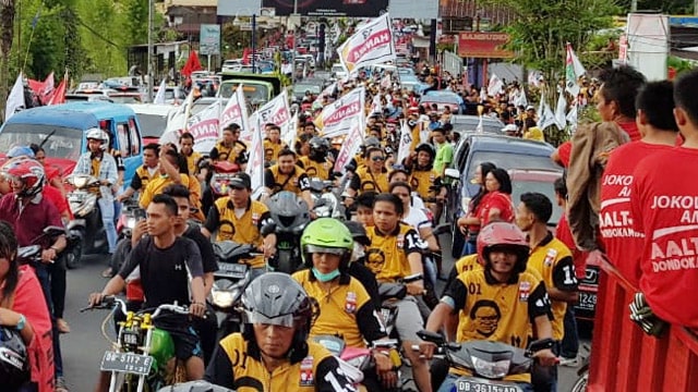Puluhan ribu orang memadati ruas jalanan sejak dari Bandar Udara Sam Ratulangi saat kedatangan Presiden RI, Joko Widodo di Kota Manado, Minggu (31/3). Presiden akan menutup rangkaian kegiatan Konferensi Persatuan Gereja di Kabupaten Minahasa Utara, Sulawesi Utara.