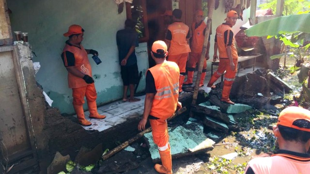 Petugas PU Jati Padang membersihkan barang-barang yang rusak karena banjir. Foto: Muhammad Darisman/kumparan