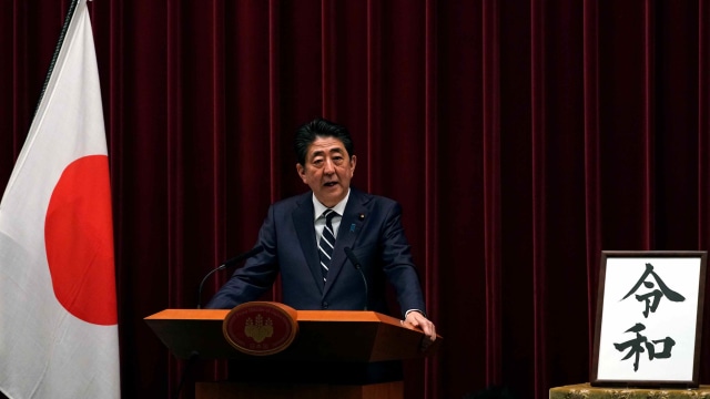 Perdana Menteri, Shinzo Abe, bersama kaligrafi bertuliskan Reiwa, sebagai nama baru era terbaru di Jepang Reiwa. Foto: Franck Robichon/Pool via Reuters