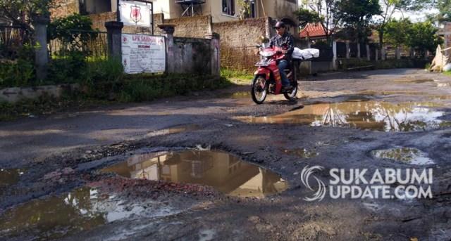 Pengendara motor menghindari lubang digenangi air di jalan desa, tepatnya di Kampung Tipar, Desa Cibolangkaler, Kecamatan Cisaat, Kabupaten Sukabumi, Selasa (2/4/2019). | Sumber Foto:CRP 1.