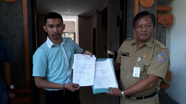 Direktur Eksekutif WALHI Bali Made Juli Untung Pratama menyerahkan dokumen sengketa informasi publik melawan Gubernur Koster, Selasa (2/4) - kanalbali/IST