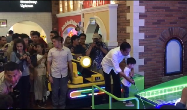 Jokowi bersama cucunya, Jan Ethes, bermain pin ball di Solo Paragon Mall pada Rabu (03/04/2019). (Agung Santoso)