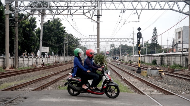 Kendaraan bermotor melewati perlintasan kereta di dekat Kantor Imigrasi Jakarta Timur, Jalan Pisangan Lama, Pulo Gadung. Foto: Iqbal Firdaus/kumparan
