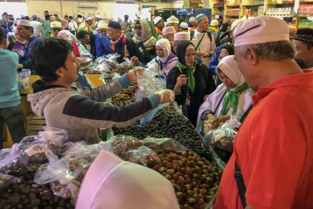 Jemaah umrah membeli kurma di pasar Madinah. Foto: Suparta/acehkini