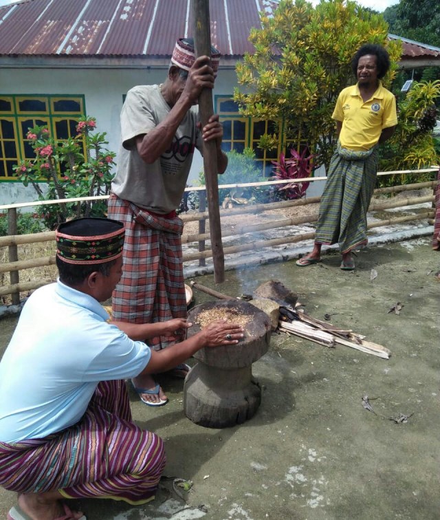 Para sesepuh kampung menumbuk padi yang telah disangrai sebelum dibagikan kepada seluruh warga kampung.Foto oleh : florespedia/kumparan.