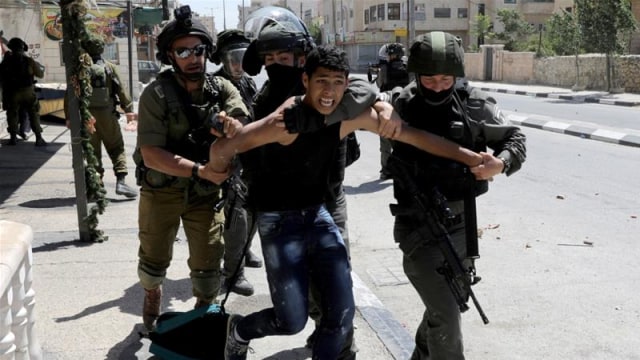 Tentara Israel saat menahan seorang warga Palestina. Foto: Reuters/Ammar Awad