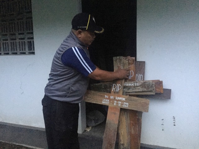Penjaga Pemakaman Umum Bethesda Yogya, Hari Yuniarto sedang merapikan nisan salib yang dicabut. Foto: Arfiansyah Panji Purnandaru/kumparan