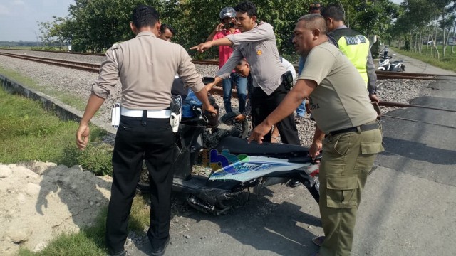 Petugas saat mengamankan sepeda motor yang terlibat kecelakaan dengan kereta api, di perlintasan tanpa palang pintu di Desa Kebonagung Kecamatan Padangan Bojonegoro. Sabtu (06/04/2019).