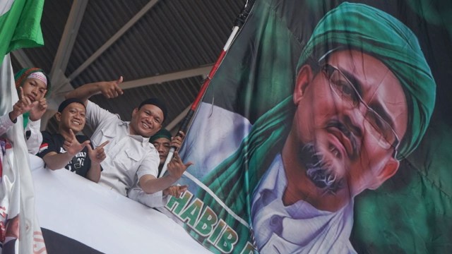 Sejumlah massa kampanye akbar Prabowo-Sandi mengibarkan bendera dengan gambar Habib Rizieq Shihab di Stadion Gelora Bung Karno Foto: Irfan Adi Saputra/kumparan