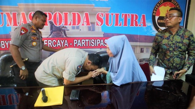 Kabid Humas Polda Sultra, AKBP Harry Goldenhardt, mencium tangan nenek Yudahusna sebagai bentuk permintaan maaf, Senin (08/04). Foto: Wiwid Abid Abadi/kendarinesiaid