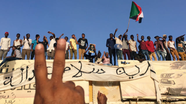 Sejumlah demonstran Sudan meneriakkan protes menuntut Presiden Sudan Omar Al-Bashir untuk mundur di luar kementerian pertahanan di Khartoum, Sudan, Senin, (8/4). Foto: REUTERS/STR
