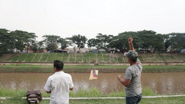 Sejumlah warga bermain layang-layang di tepi Kanal Banjir Timur, Jl. Kolonel Sugiono, Jakarta Timur, Selasa (9/4). Foto: Nugroho Sejati/kumparan