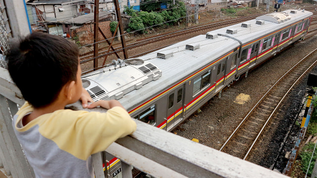 Seorang anak melihat rangkaian kereta rel listrik (KRL) Commuterline melintas di kawasan Stasiun Jatinegara. Foto: ANTARA FOTO/M Risyal Hidayat