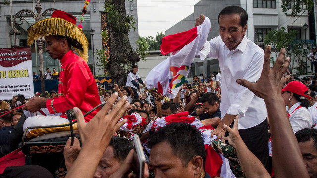 Calon Presiden no urut 01 Joko Widodo membagikan kaos kepada pendukungnya saat Kampanye Terbuka di Solo. Foto: ANTARA FOTO/Mohammad Ayudha