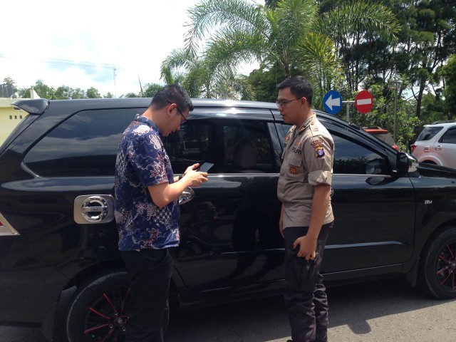 Kapolsek Arsel AKP Rendra Dani bersama korban melihat kondisi mobil korban. (Foto: Joko Hardyono)