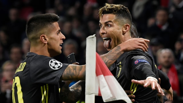 Cristiano Ronaldo merayakan gol ke gawang Ajax bersama Joao Cancelo. Foto: AFP/John Thys