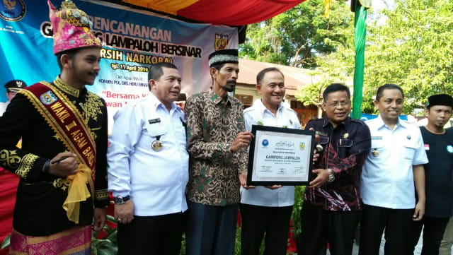 Keuchiek Gampong Lampaloh Adi Isnaini (berpeci) dan Kepala BNN Komjen Heru Winarko memegang prasasti Gampong Lampaloh sebagai Gampong Bersinar, Kamis (11/4). Foto: Husaini/acehkini