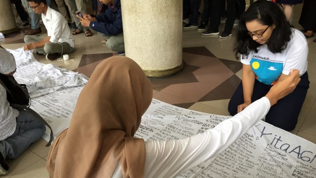 Para mahasiswa menandatangani kain untuk Kasus Agni. Foto: Istimewa
