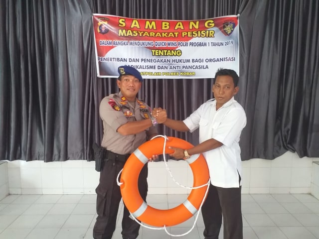 Kasatpolair Polres Kobar Iptu Herbet P. Simanjuntak memberikan pelampung kepada Kepala Desa Sungai Kapitan Mulkan. (Foto: Satpolair Polres Kobar)